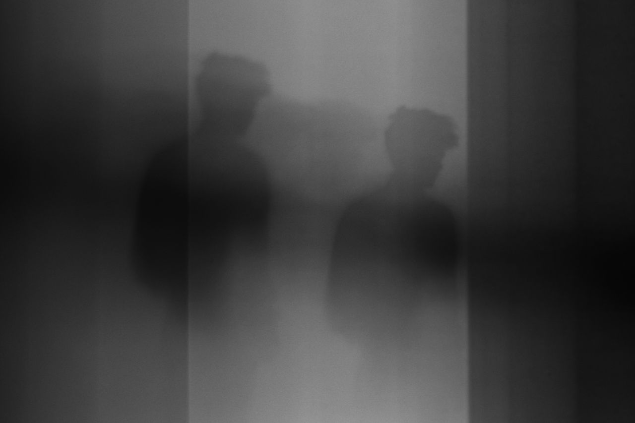 Abstract black and white photo featuring a shadowy silhouette, creating an enigmatic atmosphere.